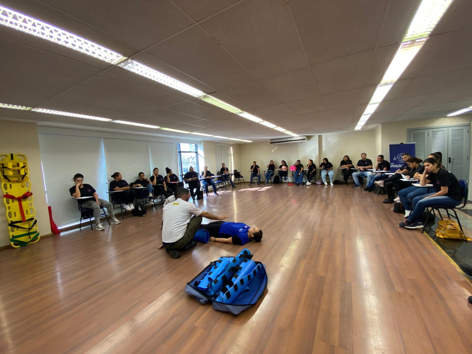 Alunos praticando imobilização em maca e prancha rígida