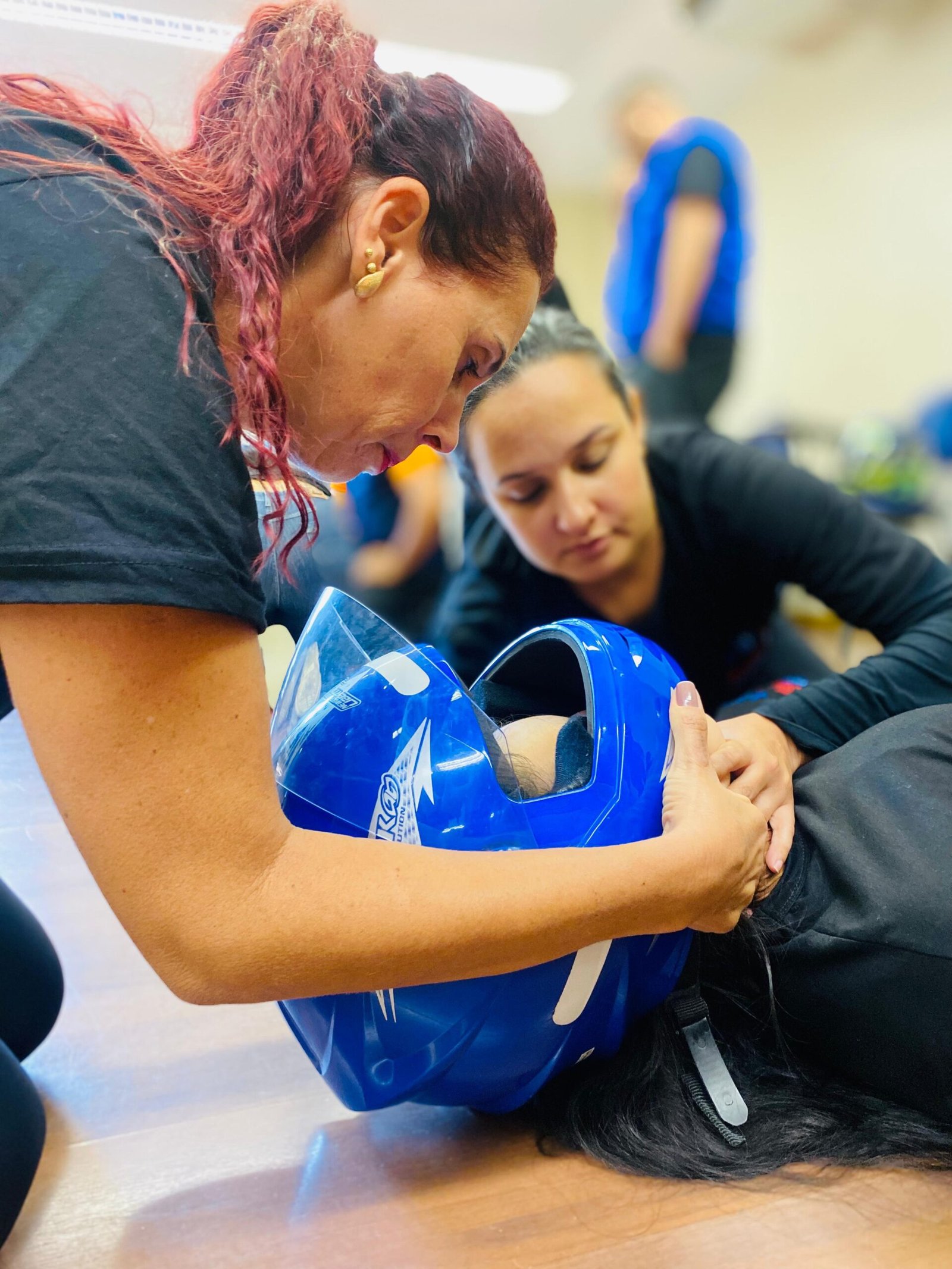 Alunos praticando remoção segura de capacete em vítima